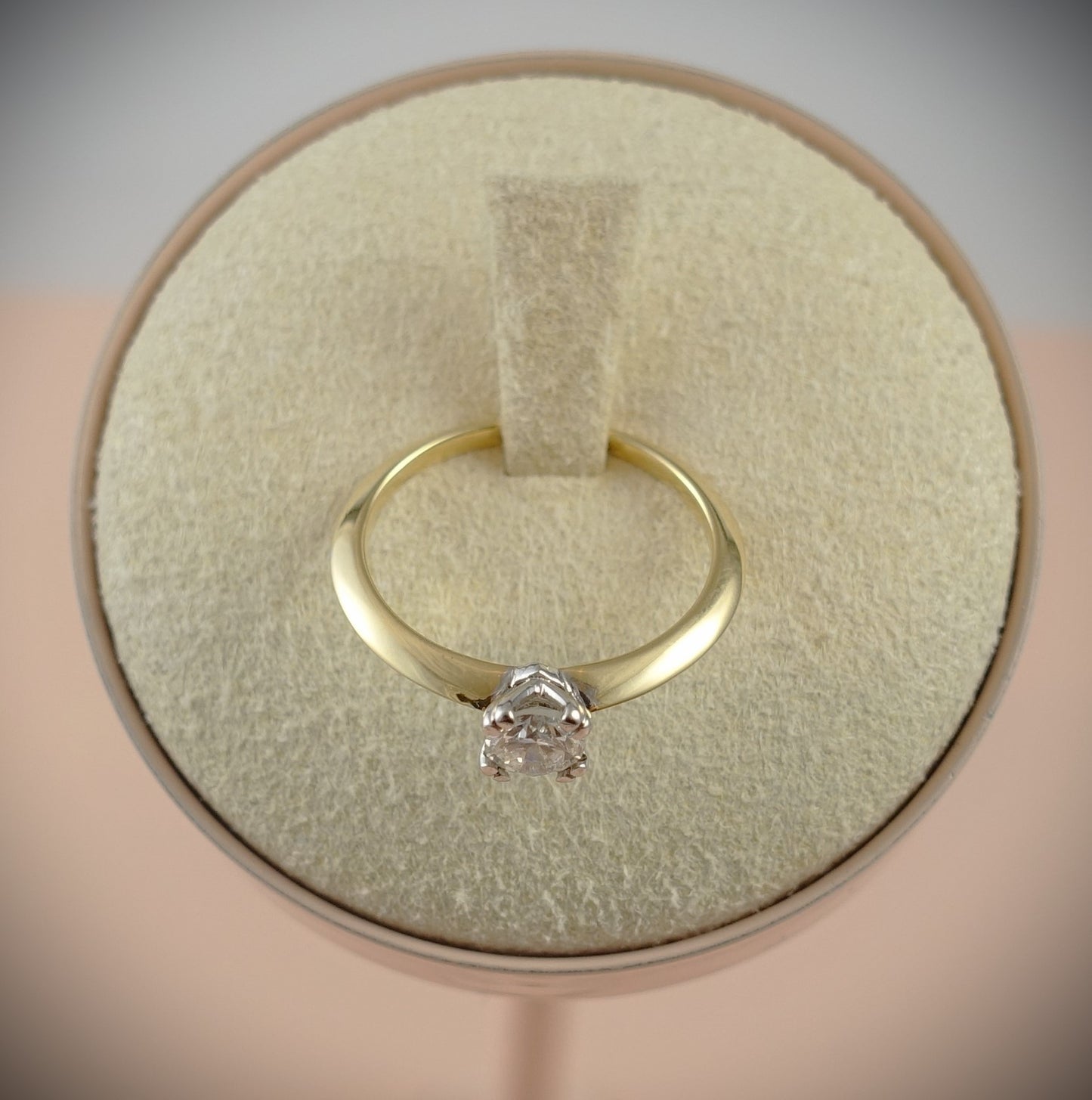 Ein Ring 750 Gelbgold 0,43 ct Brillant von Ninas Schmuckhandel, in Größe 54 mit einer SI-Qualität Krappenfassung, elegant präsentiert auf einem weichen beigen Kissen in einer runden Box.